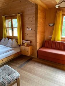 a room with two beds and a bench in a cabin at Edelweißhütte in Funes
