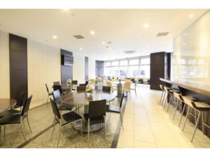 uma sala de jantar com mesas e cadeiras num edifício em R&B HOTEL HACHIOJI - Vacation STAY 38817v em Hachioji