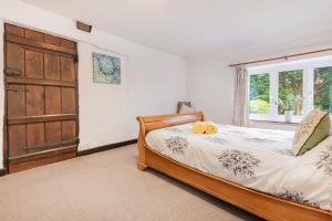un dormitorio con una cama y una ventana en Burrow Cottage, en Kendal