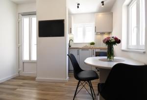 a kitchen with a table and a tv on a wall at Modern Jacuzzi Apartment Mickey in Dubrovnik