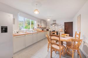 una cocina con mesa y sillas. en Burrow Cottage, en Kendal