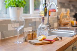 una botella de vino y una copa en la encimera de la cocina en Burrow Cottage, en Kendal 28 fotos más