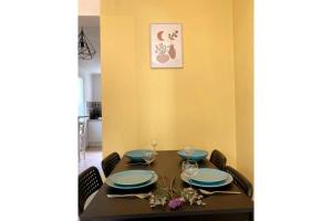 una mesa de comedor con platos y vasos azules en Appartement calme et ensoleillé Montpellier, en Montpellier