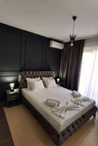 a bedroom with a large bed with a black wall at MD APARTMENTS in Ulcinj