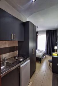 a kitchen with black cabinets and a sink and a living room at MD APARTMENTS in Ulcinj