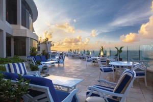 a patio with tables and chairs on a building at Condado Vanderbilt Hotel in San Juan