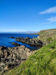 a view of the ocean from a rocky shoreline at Happy-Cove Guesthouse - by the sea in Bakkafjörður