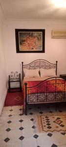 a bedroom with a bed and a painting on the wall at Riad Dar Zaida in Marrakech