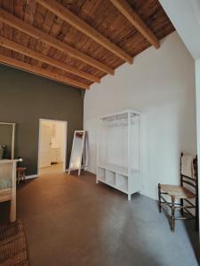 a room with white walls and a wooden ceiling at B & B Wijdzicht in Wolsum