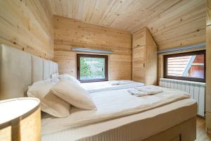 Brvnara Ljubomir, planina Tara, Kaludjerske Bare في كالودييرسكي باري: سرير كبير في غرفة خشبية مع نافذة