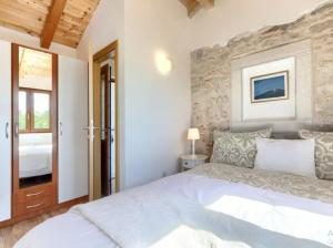 a bedroom with a white bed and a stone wall at Villa Marinko in Umag