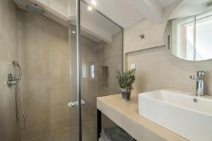 a bathroom with a sink and a shower at Bright & elegant loft suite in the city center in Zakynthos