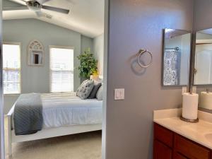 1 dormitorio con cama, espejo y lavamanos en LUX! 2 bd 2 ba Farmhouse condo Mesa/Phoenix metro, en Mesa