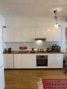 a kitchen with white cabinets and a stove top oven at Beautiful appartment in the heart of Paris in Paris