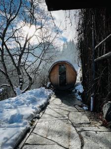 eine Holzbadewanne neben einem schneebedeckten Bürgersteig in der Unterkunft Berghaus Wiesegg - uriges Tiroler Bauernhaus in Fügenberg