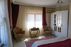 a bedroom with two chairs and a table and a bed at Villa Laila Trabzon in Trabzon