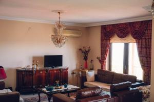 sala de estar con sofá y lámpara de araña en Villa Laila Trabzon, en Trabzon