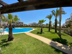 a pool with palm trees and a pathway at Casa Bellavista del Mar in Vera