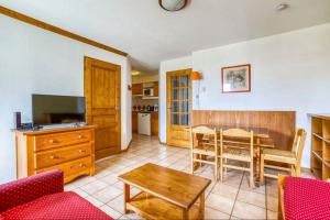 ein Wohnzimmer mit einem Tisch und einer Küche in der Unterkunft Nice Apt With Wifi Balcon In The Downtown ! in Chamonix-Mont-Blanc