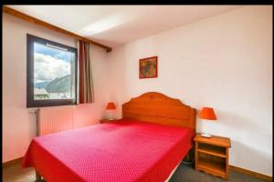 ein Schlafzimmer mit einem roten Bett und einem Fenster in der Unterkunft Nice Apt With Wifi Balcon In The Downtown ! in Chamonix-Mont-Blanc