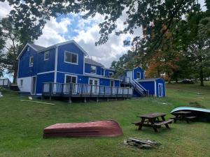 ein blaues Haus mit einem Picknicktisch davor in der Unterkunft GORGEOUS Poconos Springtime by the Lake! in Henryville