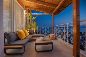 un soggiorno con un divano e un tavolo su un balcone di Panoramic view!Penthouse 120qm of sea & mountain a Loutra Edipsou