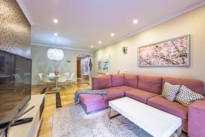 エステポナにあるMarina Luxury Apartmentのリビングルーム(ピンクのソファ、テーブル付)