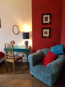 a living room with a blue couch and a desk at Apartament Rynek Staromiejski in Toruń