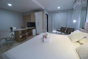 a bedroom with a large white bed and a bathroom at Marruá Hotel in Bonito