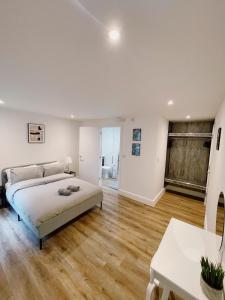a bedroom with a bed and a wooden floor at Prosper House Apartment 2 in Norwich