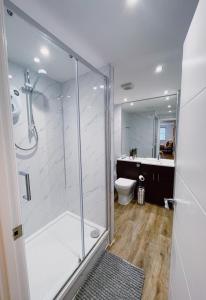 a bathroom with a glass shower and a toilet at Prosper House Apartment 2 in Norwich