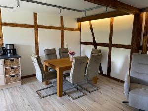 comedor con mesa de madera y sillas en Ferienwohnung Holzwurm, en Wienrode