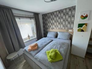 a bedroom with a bed with two green towels on it at Ferienwohnung Holzwurm in Wienrode