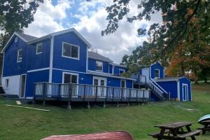 a blue house with a picnic table in front of it at Spring Poconos Getaway! 2bd Cabin in Henryville