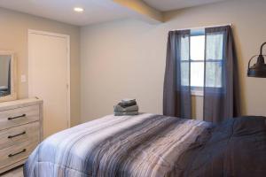 1 dormitorio con 1 cama con ventana y vestidor en Spring Poconos Getaway! 2bd Cabin, en Henryville
