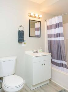 y baño con aseo blanco y lavamanos. en Spring Poconos Getaway! 2bd Cabin, en Henryville