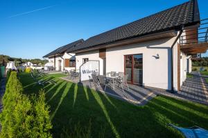 加茨比亚格拉Domki Wilena 1的一座房子,旁边是一片绿色草坪
