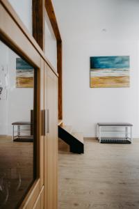um quarto com uma porta, uma mesa e pinturas em Ferienhaus in historischer Hofgasse em Mörbisch am See