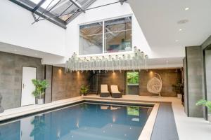 ein großer Pool in einem Haus mit einer Decke in der Unterkunft Sleeps 18. Stunning gardens, pool and hot tub. in Holbrook