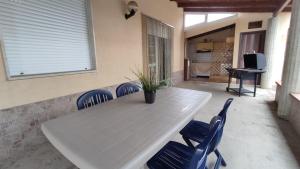 een witte tafel en stoelen met een potplant op een patio bij Grandma's House in Alcamo