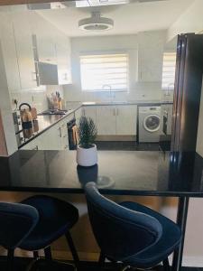 a kitchen with a table and two chairs and a sink at Lancy Apartments in Gaborone