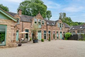 an exterior view of a house with a courtyard at Sleeps 18. Stunning gardens, pool and hot tub. in Holbrook