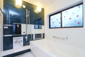 a bathroom with a tub and a shower with a window at Nagatoro fireplace - Vacation STAY 59551v in Minano