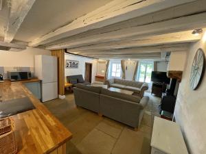 a living room with two couches and a kitchen at Champs Chevrier in Mézières-sur-Issoire