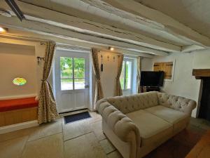uma sala de estar com um sofá e uma janela em Champs Chevrier em Mézières-sur-Issoire