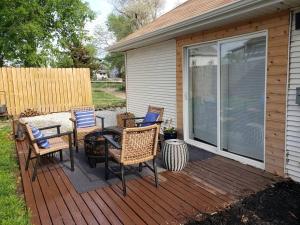 una terrazza in legno con sedie e un tavolo sopra di Cute Cottage-2 min from downtown Lincoln a Lincoln