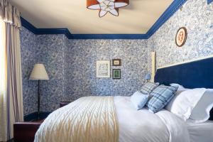 a bedroom with a bed with blue wallpaper at The Randolph Hotel Oxford, a Graduate by Hilton Hotel in Oxford +37 photos