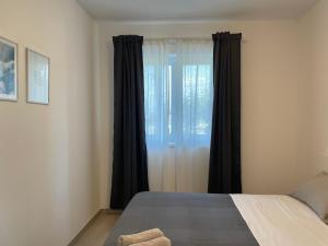 een slaapkamer met een groot raam met zwarte gordijnen bij Apartments Casa Bianca in Portorož