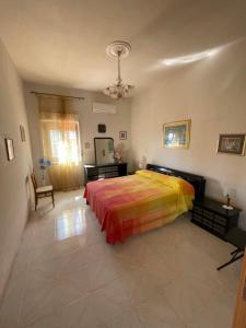 1 dormitorio con 1 cama con una manta colorida en VILLA ALBA, en Brucoli