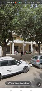 une voiture blanche est garée dans un parking dans l'établissement B&C rentals and events, à Lecce